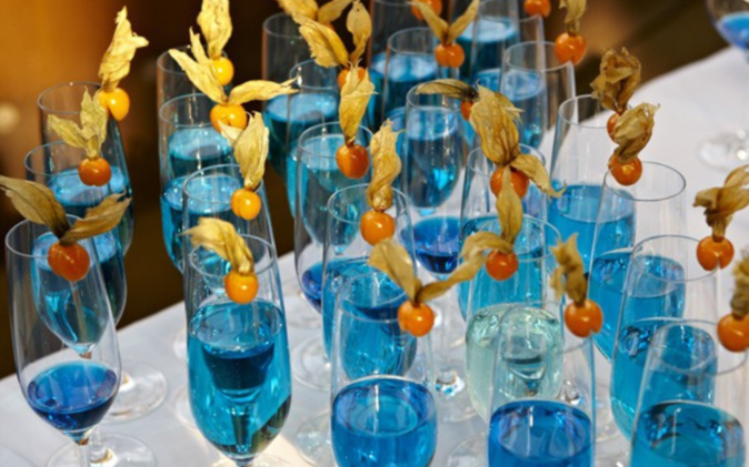 Champagner-Gläser mit blauem Getränk stehen für die Gäste bereit. 